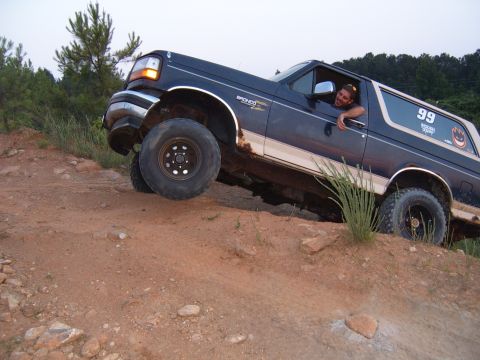 1993 Ford Bronco - A 1993 Ford Bronco navigates a steep, rocky incline on an off-road trail.