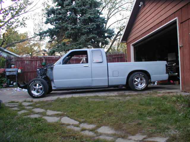 Light blue pickup truck missing front end, side view