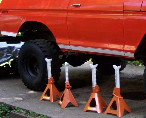 1978 Ford Bronco - This orange SUV is elevated on four jack stands, showing its undercarriage and large tires.