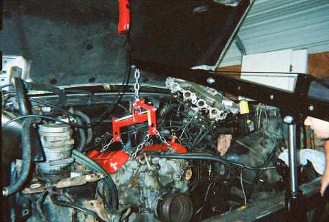 1988 Ford Bronco - Engine removal in progress for a 1988 Ford Bronco, utilizing an engine hoist and specialized lifting equipment.