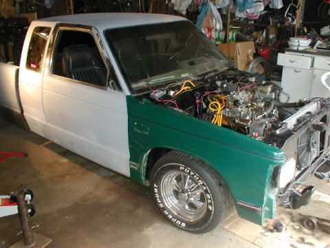 1998 Ford Taurus - Pickup truck in a garage, undergoing repairs or modification with the engine exposed.