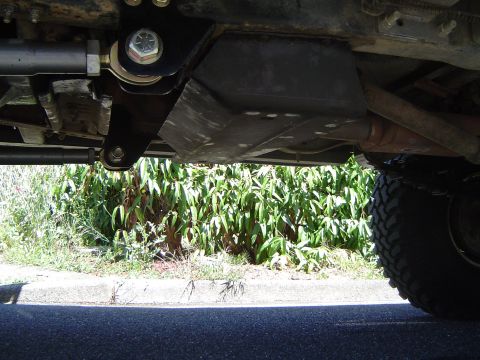 1989 Ford Bronco - Close-up view of the underbody of an off-road vehicle, showing modified suspension and skid plates.