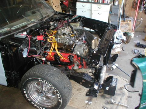 1998 Ford Taurus - Engine bay of a car undergoing repairs, showing exposed engine components and wiring.