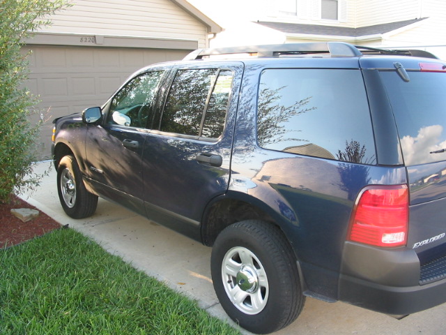 Dark blue Ford Explorer parked on a driveway, side view