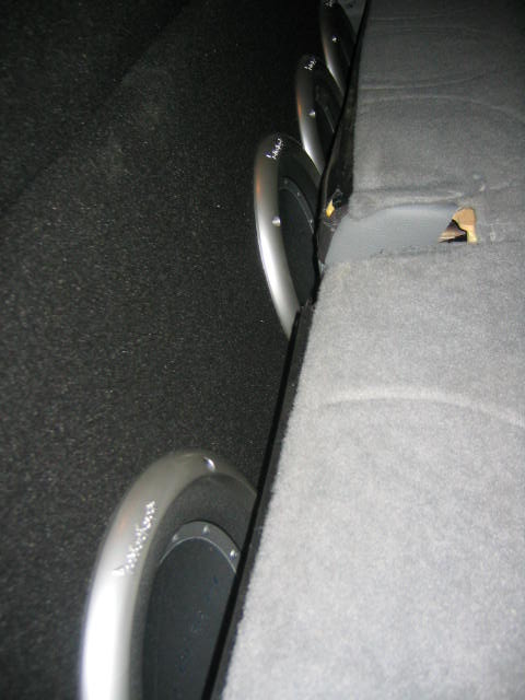 2005 Ford F-250 - Multiple subwoofer speakers are visible behind the rear seat of a vehicle, suggesting an aftermarket audio system.