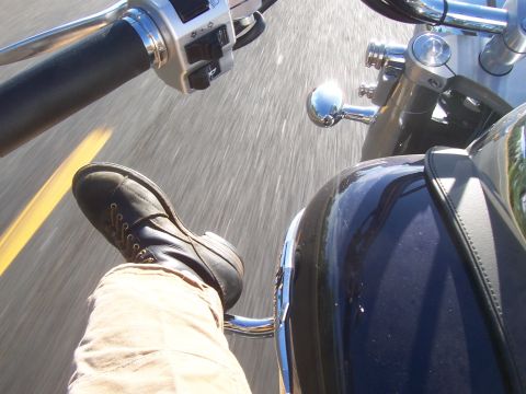 1994 Ford F-150 - Riding a motorcycle, showing the handlebars, rider's boot, and part of the dashboard.