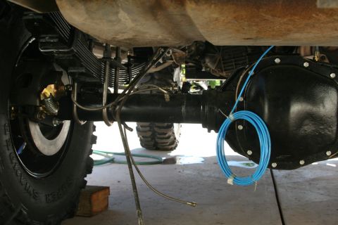 1992 Ford Bronco - Close-up of rear axle and suspension parts, showing leaf springs and brake assembly.