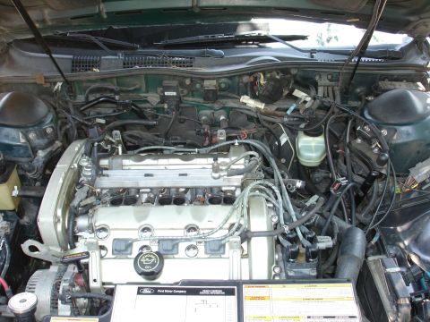 1995 Ford Taurus - Engine bay of a 1995 Ford Taurus, showing the V6 engine and associated components.