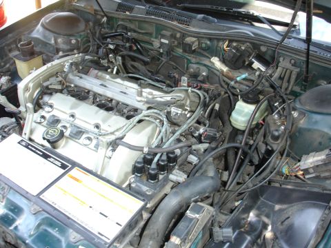 1995 Ford Taurus - Close-up view of a car's engine compartment, showing intricate wiring and mechanical parts.