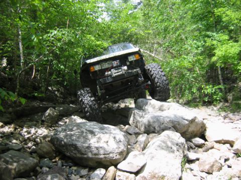 1981 Ford Bronco - This vehicle is navigating a challenging rocky terrain, with its tires gripping the stones.