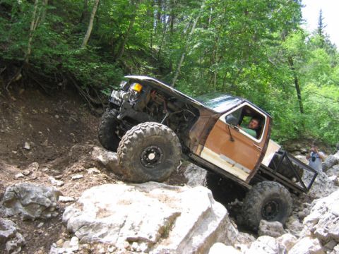 1981 Ford Bronco - Modified 1981 Ford Bronco navigates a challenging rocky terrain on an off-road trail.