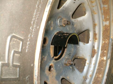 1989 Ford Bronco - Close-up view of a vehicle's wheel and tire assembly, showing rust and wear on the metal rim.
