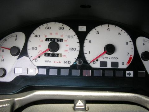 1994 Ford Probe - A car's interior shows the instrument cluster with a speedometer and tachometer.