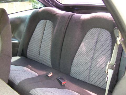 1994 Ford Probe - The rear seats of the vehicle are visible, patterned upholstery and seatbelt mechanisms.