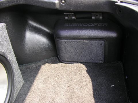 1994 Ford Probe - The trunk of a vehicle features a black subwoofer enclosure with the word 'SUBWOOFER' embossed on top.