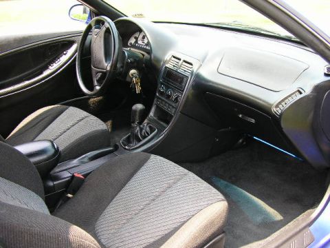 1994 Ford Probe - The interior of a 1994 Ford Probe GT is captured, highlighting the driver's side controls and passenger seating.