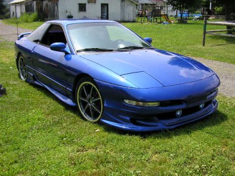1994 Ford Probe - A blue sports coupe with custom body modifications sits on a grassy lawn.