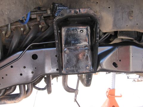 1990 Ford Bronco - Underside view of vehicle chassis with engine parts and a C-clamp securing a bracket.
