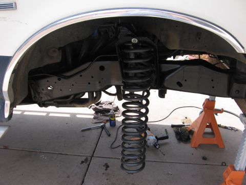 1990 Ford Bronco - Front suspension coil spring removed from a 1990 Ford Bronco, supported by jack stands.