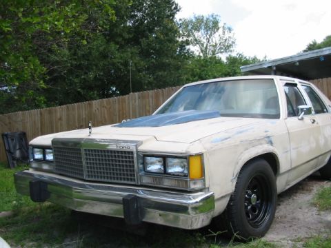 1985 Ford LTD Crown Victoria - This 1985 Ford Crown Victoria LTD is seen from a 3q-front angle, a prominent blue hood scoop.
