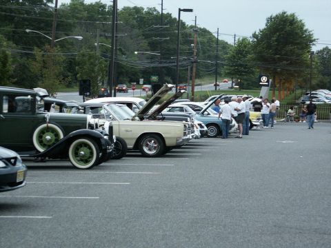 2001 Mercury Grand Marquis - A gathering of vintage automobiles is displayed in a parking lot on an overcast day.