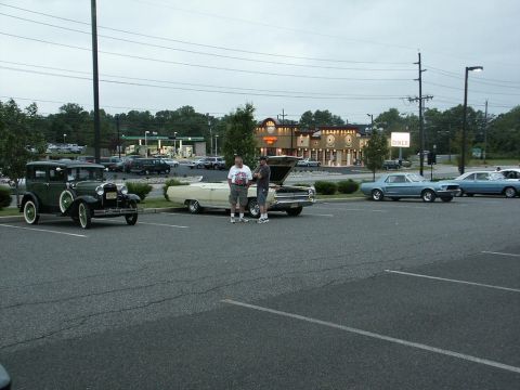 2001 Mercury Grand Marquis - Several classic cars are parked in a lot outside a diner on an overcast day.