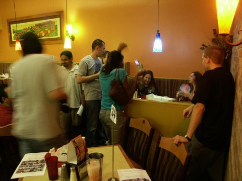 2001 Mercury Grand Marquis - A group of people are gathered inside a restaurant, with tables and booths visible.