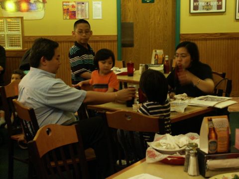 2001 Mercury Grand Marquis - A family dines at a restaurant, with children and adults seated around tables.