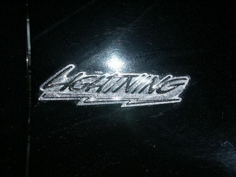 2001 Mercury Grand Marquis - A chrome emblem with the word "Lightning" is visible on a black surface, possibly a vehicle part.