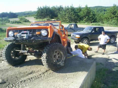 1994 Ford Bronco - Modified off-road vehicle with winch and two Ford trucks in the background.