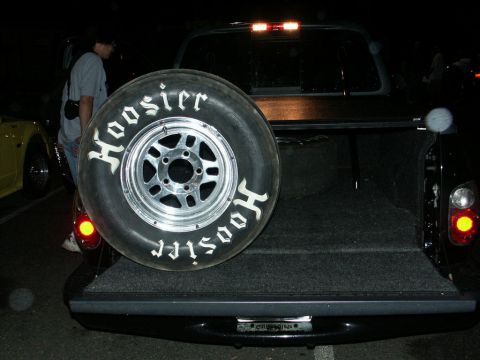 2001 Mercury Grand Marquis - A spare Hoosier tire is mounted in the bed of a black pickup truck, with another vehicle visible to the left.
