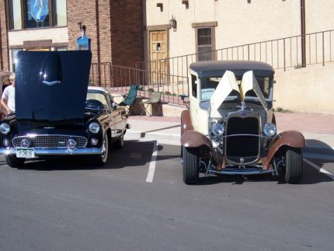 1972 Ford Ranchero - A black 1955 Ford Thunderbird and an older model car are parked side-by-side with their hoods up.