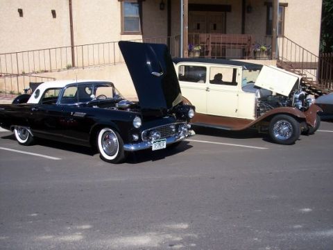 1972 Ford Ranchero - A black 1956 Ford Thunderbird is displayed with its hood open, alongside a vintage cream and brown sedan.