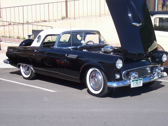 Black 1956 Ford Thunderbird convertible with white roof and hood open