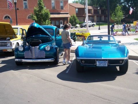 1972 Ford Ranchero - A blue 1969 Chevrolet Corvette convertible is parked at an outdoor event, with other vehicles and people in the background.