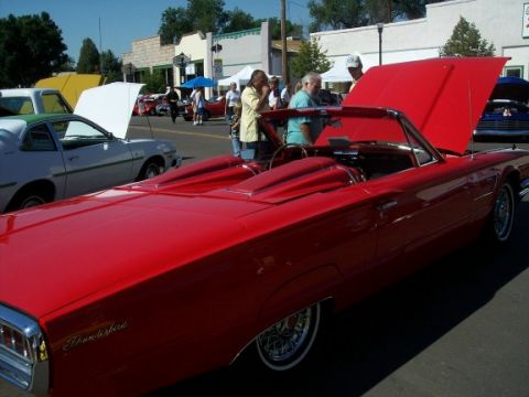 1972 Ford Ranchero - A red 1961 Ford Thunderbird convertible is displayed with its hood open at an outdoor car show.