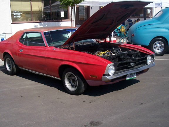 Red 1971 Ford Mustang coupe with hood open, parked next to a blue car