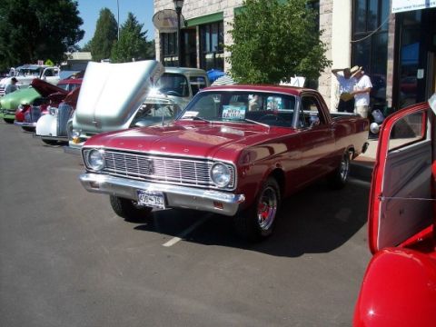 1972 Ford Ranchero - A red Ford Ranchero is parked on a street, with other vehicles and buildings visible.