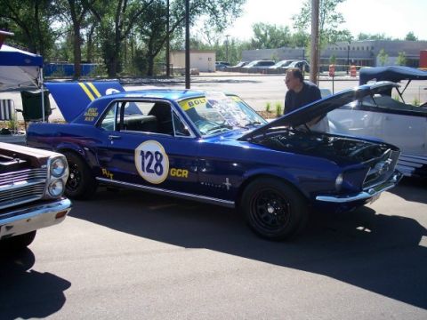 1972 Ford Ranchero - A blue 1967 Ford Mustang race car with its hood open is parked outdoors next to another vehicle.