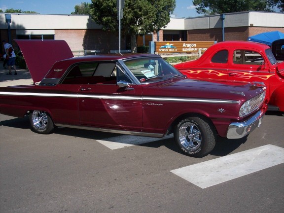 Maroon Ford Falcon with white side trim, hood and trunk open, chrome wheels