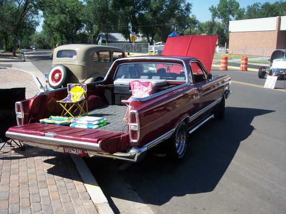 Maroon 1968 Ford Ranchero with tailgate down, showing chairs and cooler in bed