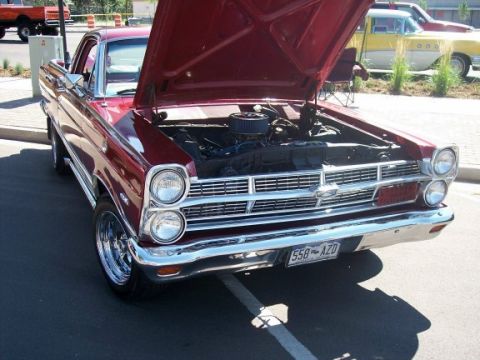 1972 Ford Ranchero - A red 1966 Ford Fairlane is parked with its hood up, revealing the engine bay. Another vehicle is visible in the background.