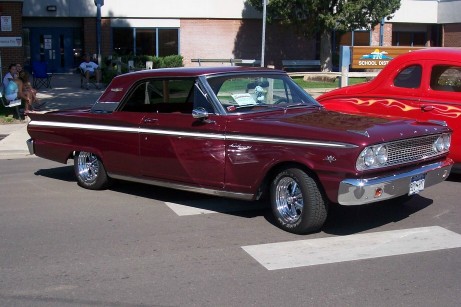 1972 Ford Ranchero - A maroon 1963 Ford Falcon Ranchero is parked next to a red hot rod at a car show.