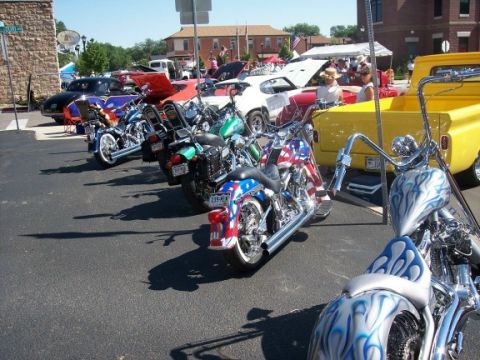 1972 Ford Ranchero - A collection of motorcycles and cars are displayed outdoors on a sunny day.