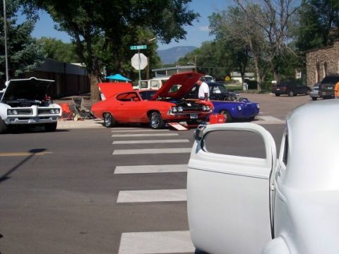 1972 Ford Ranchero - A collection of vintage automobiles are displayed with open hoods on a sunny day, suggesting a car show or gathering.
