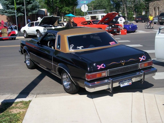 Black coupe with gold roof, rear view. License plate 502 JJD