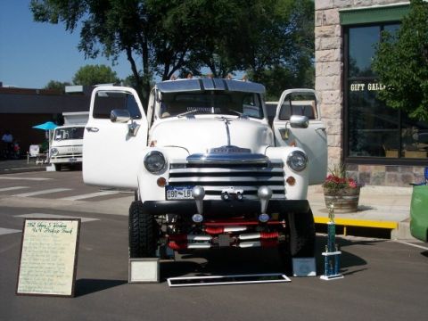 1972 Ford Ranchero - A white 1952 Chevrolet 3100 4x4 pickup truck is displayed with its doors open, a prominent grille and trophy.