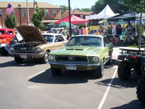 1972 Ford Ranchero - A green 1967 Ford Mustang is parked at an outdoor event, with tents and other vehicles visible in the background.