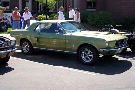 1972 Ford Ranchero - A green 1967 Ford Mustang is parked at an outdoor event with people and other vehicles nearby.