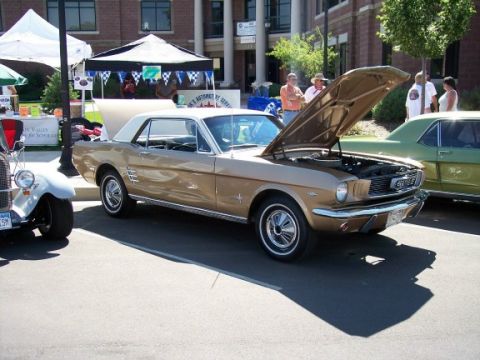 1972 Ford Ranchero - A gold 1965 Ford Mustang coupe is displayed with its hood open at an outdoor event.